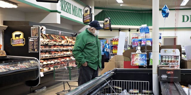 A supermarket shopper browses the meat department in Princeton, Illinois, in mid-April. Analysts predict consumers may see fewer cuts, and increased prices, within the coming weeks.