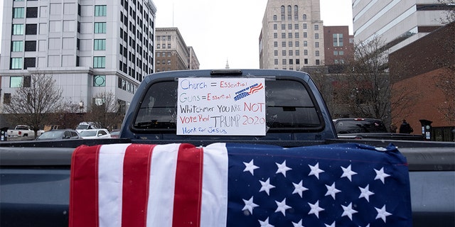 A placard hangs on a truck's window as hundreds of supporters of the Michigan Conservative Coalition protest against the state's extended stay-at-home order, as the spread of COVID-19 continues, at the Capitol building in Lansing, Michigan, U.S., April 15, 2020. (REUTERS/Seth Herald)