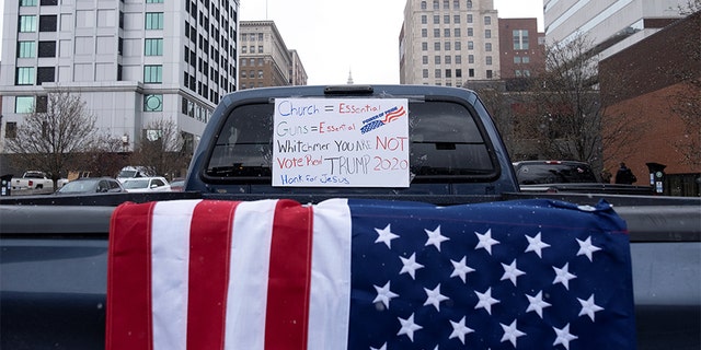 A placard hangs on a truck's window as hundreds of supporters of the Michigan Conservative Coalition protest against the state's extended stay-at-home order, as the spread of COVID-19 continues, at the Capitol building in Lansing, Michigan, U.S., April 15, 2020. (REUTERS/Seth Herald)