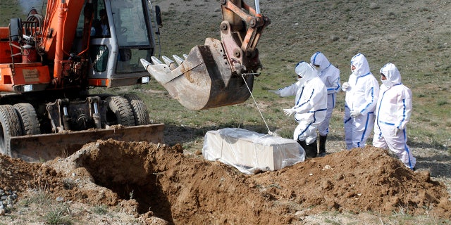 March 27, 2020: Municipality workers bury the body of coronavirus victim on the outskirts of Herat province west of Kabul, Afghanistan. Across the Middle East and parts of South Asia, bereaved families have faced traumatic restrictions on burying their dead amid the pandemic. Religion and customs that require speedy burials in the largely Muslim region have clashed with fears of COVID-19 contagion and government-mandated lockdowns. (AP Photo/Hamed Sarfarazi)