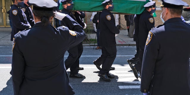 Members of the NYPD Honor Guard, wearing masks, carry the casket of Traffic Section Commander Mohammed Chowdhury during his funeral in New York on Wednesday.