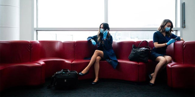 Another photo shows her and a co-worker sitting at Seattle-Tacoma International Airport, where she wrote that it was “hard to remember to maintain distance when you’re so used to working in close quarters.”