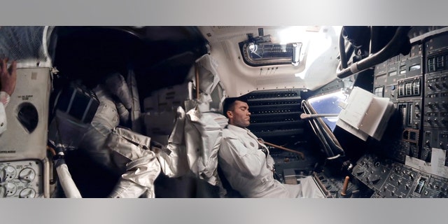 The panoramic hi-def image of interior of the Apollo 13 Lunar Module. Astronaut Fred Haise (right) is napping, while Jack Swigert can be seen curled up in the storage area. Commander Jim Lovell's hand can be seen in the left of the picture.