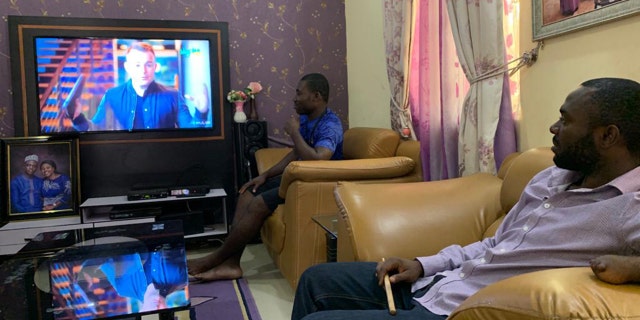 Two men in Nigeria watch Nick Hall speak during Pulse’s Good Friday service Friday, April 10.