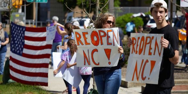 Protesters from a grassroots organization called REOPEN NC demonstrate against the North Carolina coronavirus lockdown at a parking lot adjacent to the North Carolina State Legislature in Raleigh, North Carolina, on April 14, 2020. - The group was demanding the state economy be opened up no later than April 29.