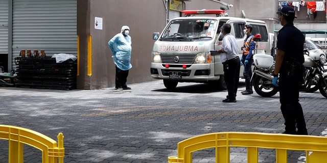 Security and police officers are seen outside the entrance to Westlite Dormitory in Singapore, one of two dormitories designated as isolation areas to curb the spread of coronavirus