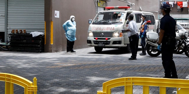 Security and police officers are seen outside the entrance to Westlite Dormitory in Singapore, one of two dormitories designated as isolation areas to curb the spread of coronavirus