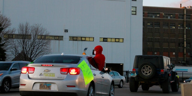 A worker is seen protesting outside the Smithfield Foods processing plant in Sioux Falls, S.D., earlier this week following a coronavirus outbreak currently affecting hundreds of the plant's workers. (AP Photo/Stephen Groves File)