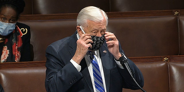 In this image from video, Rep. Steny Hoyer, D-Md., takes his face covering off as he speaks on the floor of the House of Representatives at the U.S. Capitol in Washington, Thursday, April 23, 2020. (House Television via AP)