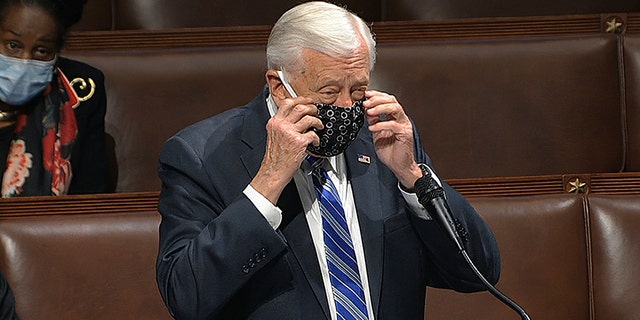 In this image from video, Rep. Steny Hoyer, D-Md., takes his face covering off as he speaks on the floor of the House of Representatives at the U.S. Capitol in Washington, Thursday, April 23, 2020. (House Television via AP)