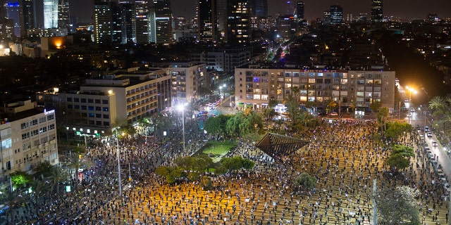 People keep social distancing amid concerns over the country's coronavirus outbreak, during a protest against Prime Minister Benjamin Netanyahu in Tel Aviv, Israel, Sunday, April 19, 2020. More than 2,000 people took to the streets on Sunday, demonstrating against Prime Minister Benjamin Netanyahu's attempts to form an "emergency" government with his chief rival and accusing him of using the coronavirus crisis to escape prosecution on corruption charges. (AP Photo/Oded Balilty)