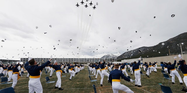 Cadets toss their hats in the air after being commissioned as officers as the Thunderbirds fly over the graduation ceremony for the class of 2020 at the U.S. Air Force Academy, Saturday, April 18, 2020, at Air Force Academy, Colo.