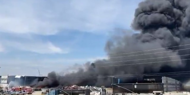 A fire burns at a warehouse in Mt. Juliet, Tenn. that had a cleanup operation ongoing since a tornado struck the building in March.