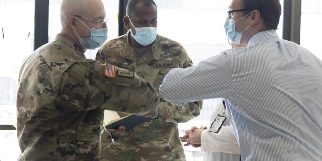 Col. (Dr.) Michael J. Sorna (left) with the U.S. Army’s Urban Augmentation Medical Task Force 332-1, 332nd Medical Brigade out of Nashville, and Dr. William Holubek of the University Hospital in Newark, exchanging a welcoming elbow tap.