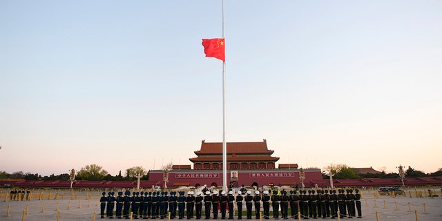 In this photo released by China's Xinhua News Agency, an honor guard stands in formation as a Chinese national flag flies at half-staff at Tiananmen Square in Beijing, on Saturday.