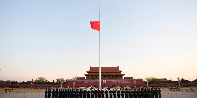 In this photo released by China's Xinhua News Agency, an honor guard stands in formation as a Chinese national flag flies at half-staff at Tiananmen Square in Beijing, on Saturday.