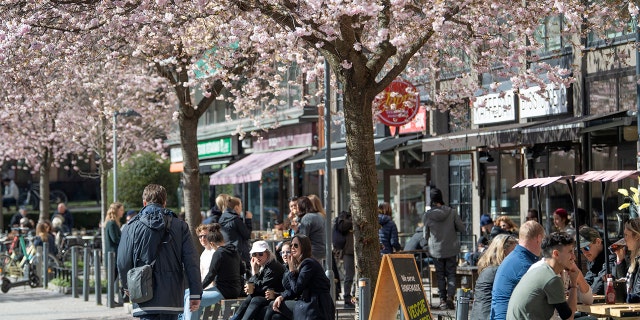 People sit outside in the sun in central Stockholm Saturday April 11, 2020. Swedish authorities have advised the public to practice social distancing because of the coronavirus pandemic, but still allow a large amount of personal freedom, unlike most other European countries. The new coronavirus causes mild or moderate symptoms for most people, but for some, especially older adults and people with existing health problems, it can cause more severe illness or death. (Anders Wiklund/TT via AP)