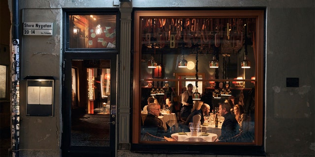 FILE - In this Wednesday, March 25, 2020 file photo people sit in a restaurant in Stockholm. Sweden is pursuing relatively liberal policies to fight the coronavirus pandemic, even though there has been a sharp spike in deaths. (AP Photo/David Keyton, File)