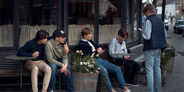 FILE - In this Wednesday, April 8, 2020 file photo youths hang out outside a restaurant in Stockholm, Sweden. (AP Photo/Andres Kudacki, File)