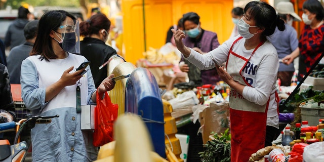 People buy food in Wuhan, capital of central China's Hubei Province, April 16, 2020. As the coronavirus epidemic wanes, life returns to normal in Wuhan gradually. 