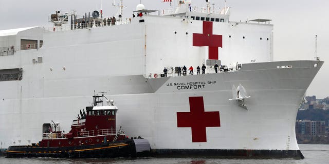 In this March 30, 2020 file photo, the U.S. Navy hospital ship USNS Comfort is escorted up the Hudson River on its way to New York City. On Tuesday, April 21, 2020, while expressing confidence that stresses on New York City's hospital system are easing, New York Gov. Andrew Cuomo said that the ship deployed to New York City to help fight the coronavirus outbreak is no longer needed.