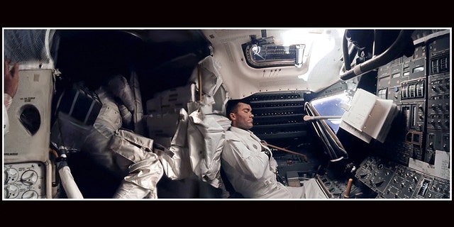 The panoramic hi-def image of interior of the Apollo 13 Lunar Module. Astronaut Fred Haise (right) is napping, while Jack Swigert can be seen curled up in the storage area. Commander Jim Lovell's hand can be seen in the left of the picture.