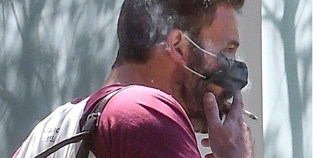 Ben Affleck was spotted smoking a cigarette with his protective mask partially off.