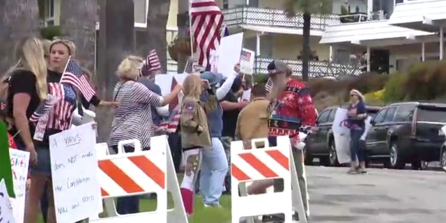 Hundreds gathered Sunday in San Clemente, Calif. gathered to protest California's stay-at-home order meant to slow the spread of coronavirus.