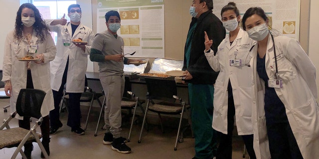 Emergency room staff at St. Charles Hospital in Port Jefferson, New York, dig into a home-cooked meal donated by an out-of-work local chef. (Courtesy: Omar Karasu)