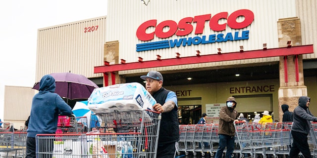 A man is shown pushing a cart outside a Costco supermarket in Los Angeles, California, in March 14, 2020. 