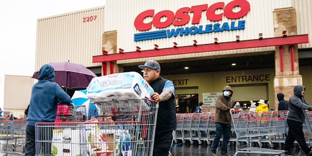 A man is shown pushing a cart outside a Costco supermarket in Los Angeles, California, in March 14, 2020. 