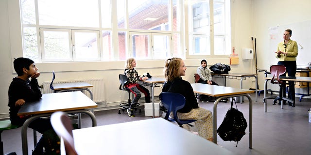 Denmark's Prime Minister Mette Frederiksen, right, speaks to pupils during the reopening of Lykkebo School in Copenhagen, Wednesday, April 15, 2020. (Philip Davali/Ritzau Scanpix via AP)