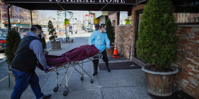 Employees deliver a body at Daniel J. Schaefer Funeral Home, Thursday, April 2, 2020, in the Brooklyn borough of New York City. The company is equipped to handle 40-60 cases at a time. But amid the coronavirus pandemic, it was taking care of 185 Thursday morning. (AP Photo/John Minchillo)