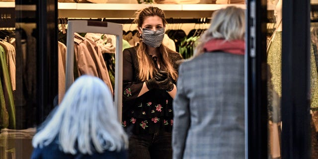 A saleswoman waits for customers in a shop as many smaller stores are allowed to open in Essen, Germany, on Monday. (AP Photo/Martin Meissner)
