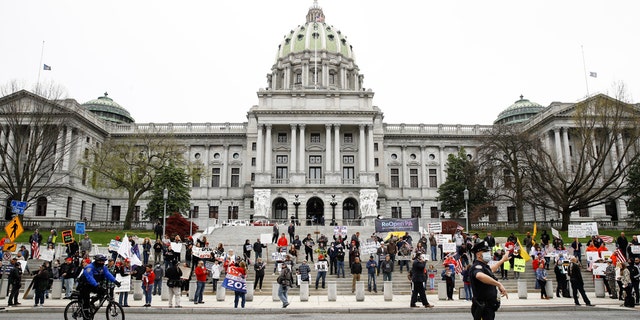 Protesters demonstrate at the state Capitol in Harrisburg, Pa., Monday, April 20, 2020, demanding that Gov. Tom Wolf reopen Pennsylvania's economy even as new social-distancing mandates took effect at stores and other commercial buildings. (AP Photo/Matt Rourke)