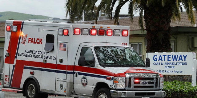 An ambulance leaves the Gateway Care and Rehabilitation Center on Thursday. At least 13 patients at the facility have died of coronavirus, and 41 others have been infected.