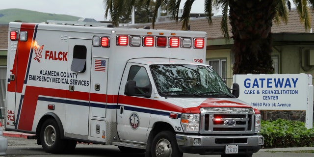 An ambulance leaves the Gateway Care and Rehabilitation Center on Thursday. At least 13 patients at the facility have died of coronavirus, and 41 others have been infected.