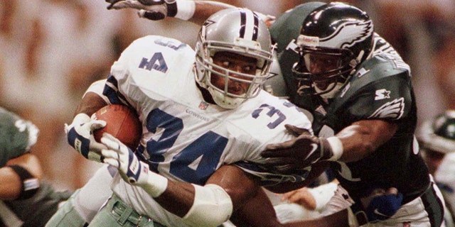 Dallas Cowboys running back Herschel Walker, left, tries to elude Philadelphia Eagles defender Derrick Whitherspoon.