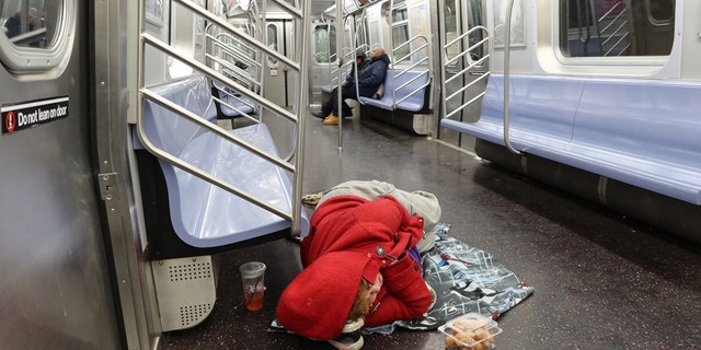 A homeless person sleeps on the floor of a subway car, Dec. 5, 2019, in New York City. (Gary Hershorn / FOX News)