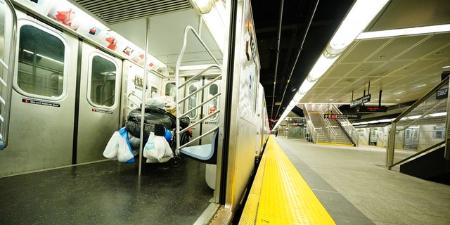 A homeless person takes shelter in a subway train AT Hudson Yards, New York City during a rainy afternoon amid COVID-19 pandemic on April 3, 2020. (Photo by John Nacion/NurPhoto via Getty Images)