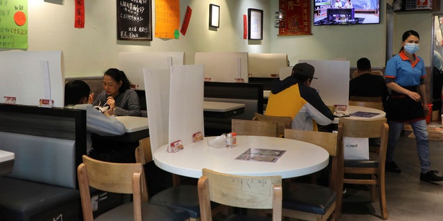 Customers have breakfast with plastic panels set up on the tables to protect themselves from possibly contracting the coronavirus COVID-19 at a restaurant in Hong Kong, Saturday, April 18, 2020.