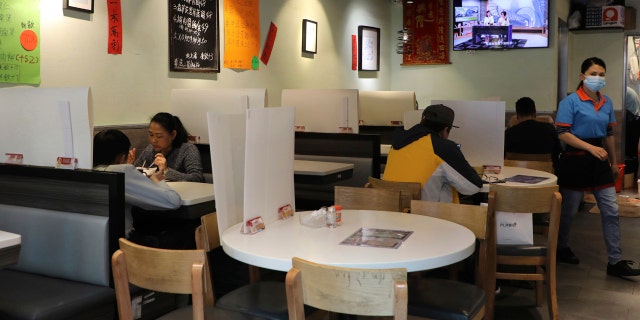Customers have breakfast with plastic panels set up on the tables to protect themselves from possibly contracting the coronavirus COVID-19 at a restaurant in Hong Kong, Saturday, April 18, 2020.