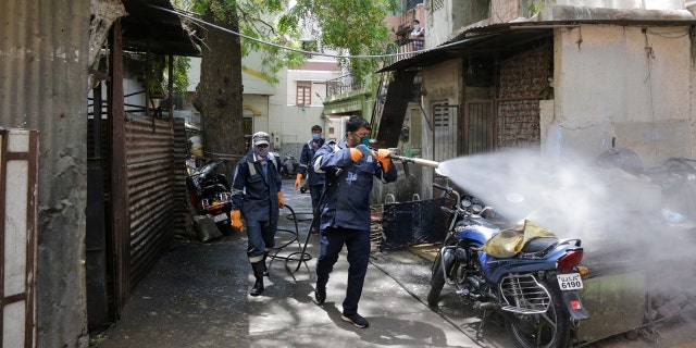 Fire service personnel spray disinfectant in a residential area during lockdown to prevent the spread of new coronavirus in Ahmedabad, India, Wednesday.