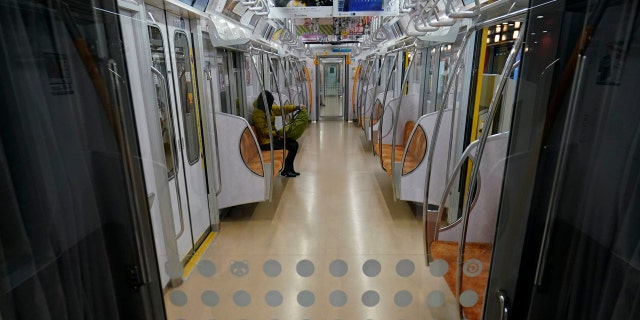 A woman rides an empty subway Monday, April 13, 2020, in Tokyo.