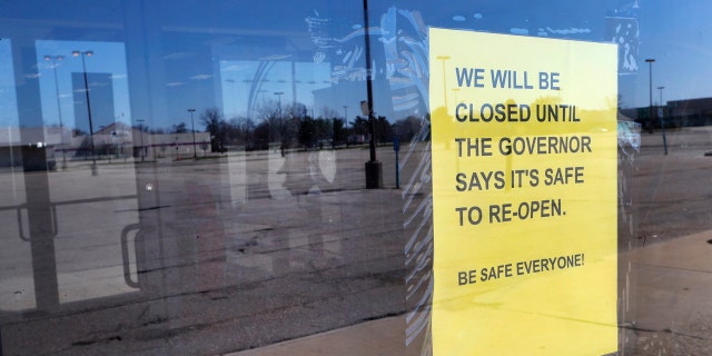A closed sign is shown at Romeo & Juliet Furniture and Appliances with an empty parking lot in Detroit, Thursday, April 2, 2020.