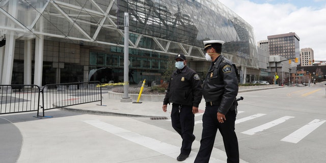 In this April 10, 2020, photo, Captain Jevon Johnson of Detroit, right, speaks with Lieutenant Pride Henry outside the TCF Center in Detroit.