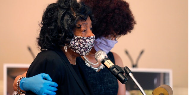 Lillian P. Hammond, foreground, is comforted by her sister-in-law Lori Adams, as she speaks at the funeral funeral for her husband Larry Hammond, who died from the coronavirus, in New Orleans, April 22. (AP Photo/Gerald Herbert)