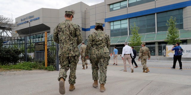 Trump slams 'complaining' Dem Pritzker at coronavirus briefing, signals openness to more stimulus checks 3 National Guard personnel walking outside the Ernest N. Morial Convention Center in New Orleans, after officials set up a temporary hospital there amid the coronavirus.