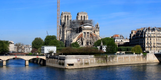 A crane stands by Notre Dame Cathedral on April 15. Work began Monday to refit the construction site to protect workers from the virus and allow cleanup efforts to resume. (AP)