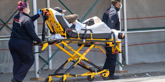 Medics transport a patient to the King David Center for Nursing and Rehabilitation in the Gravesend neighborhood of the Brooklyn borough of New York, Wednesday, April 15, 2020. Federal health officials are coming under increasing pressure to start publicly tracking coronavirus infections and deaths in nursing homes amid criticism they have not been transparent about the scope of outbreaks across the country that have already claimed thousands of lives. 